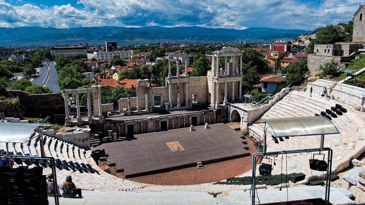 Ancient Roman theatre in Plovdiv's Old Town, with the city and mountains beyond